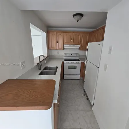 a kitchen with a refrigerator and a sink