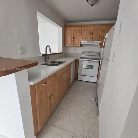a kitchen with white cabinets sink and appliances