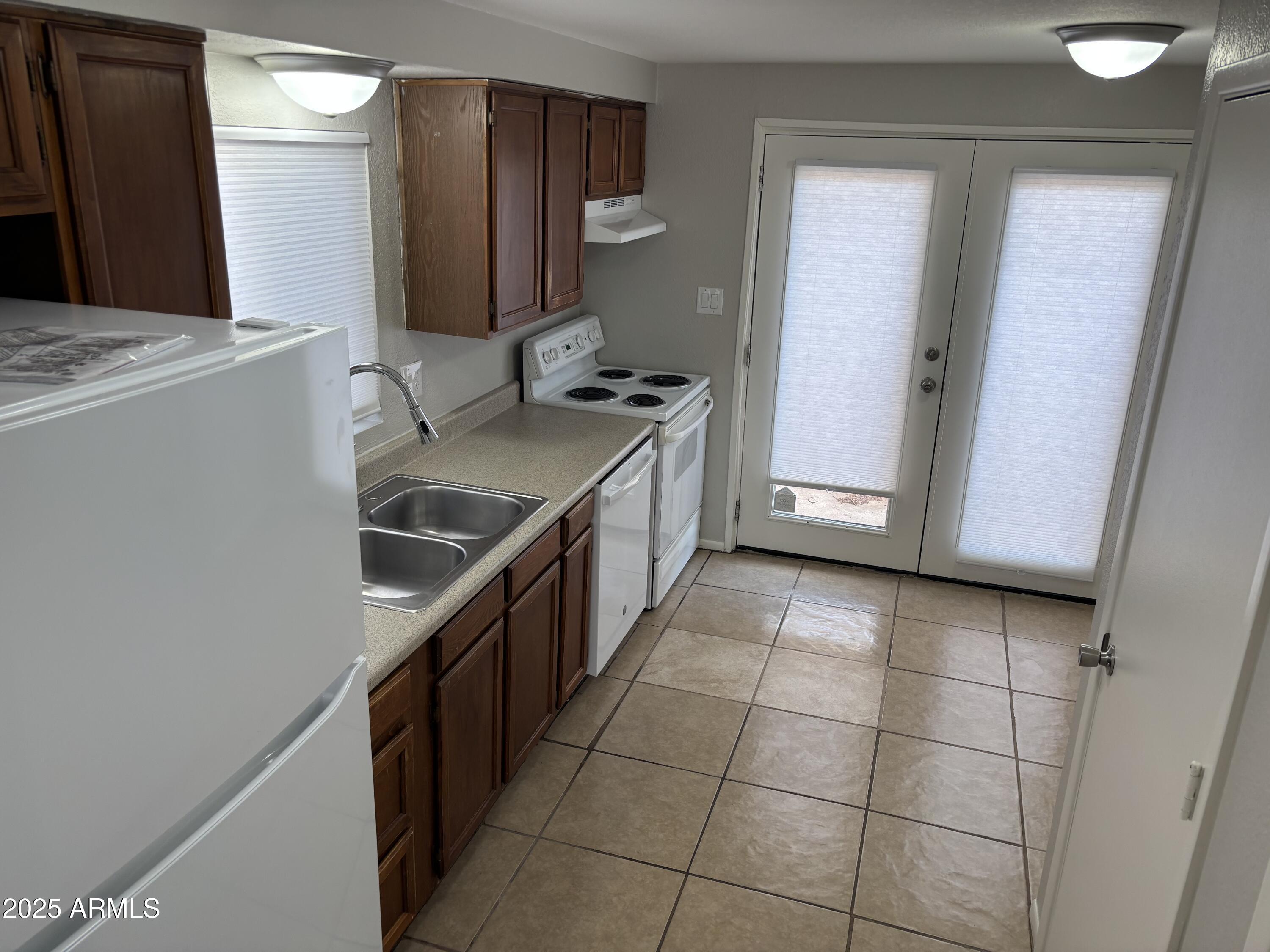 148 South 54th Street, Unit A Mesa, AZ 85206 - Photo 10 of 11 a kitchen with stainless steel appliances a sink stove and cabinets