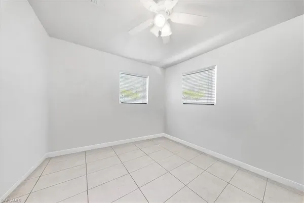 an empty room with a fan and a window
