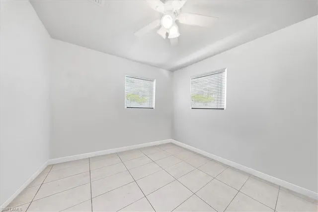 an empty room with a fan and a window