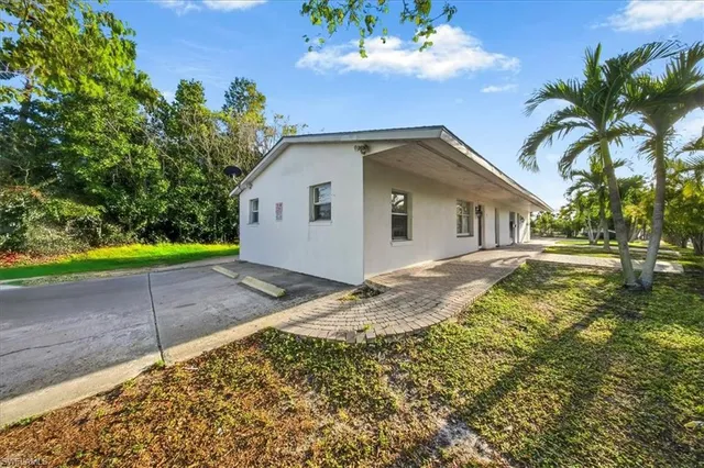 a view of a white house with a yard and plants