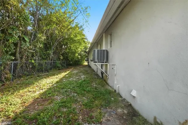 a view of a house with a yard and large tree