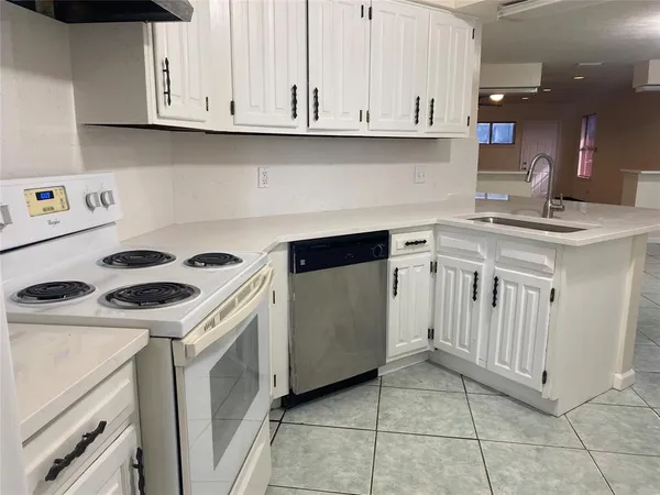 a kitchen with granite countertop a sink a stove and cabinets