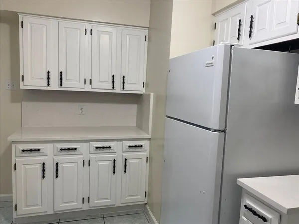 a white refrigerator freezer and a stove sitting inside of a kitchen