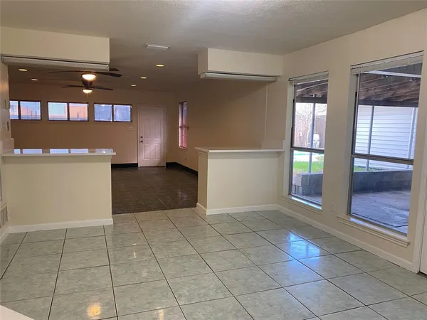 a view of a hallway with an empty room and chandelier