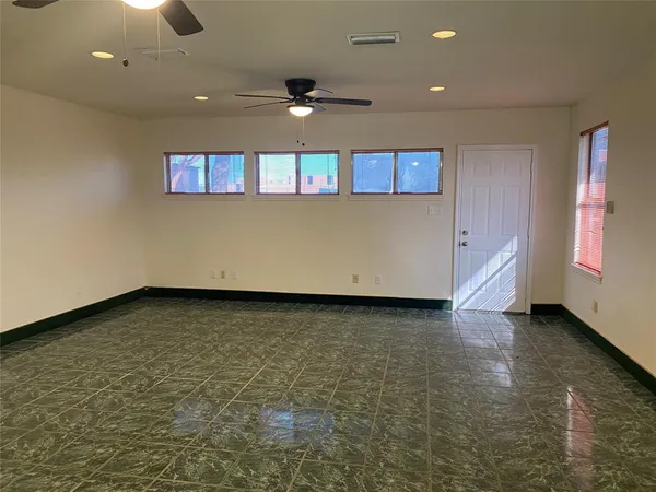 an empty room with a ceiling fan and window