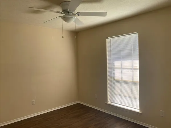 an empty room with a window and wooden floor