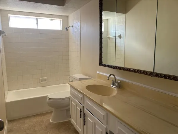 a bathroom with a granite countertop sink a toilet and bathtub