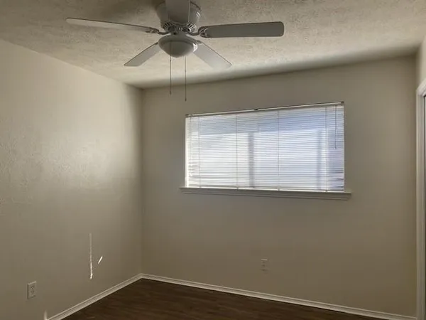 an empty room with a window and a ceiling fan