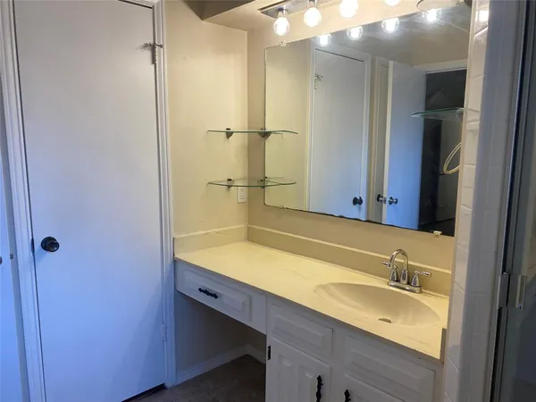 a bathroom with a granite countertop sink and a mirror