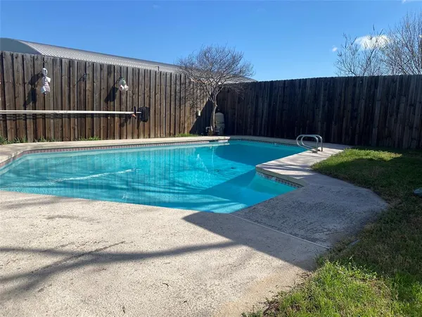 a view of backyard with wooden fence