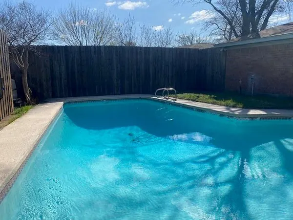 a view of swimming pool with wooden fence