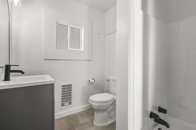 a bathroom with a toilet a sink and mirror