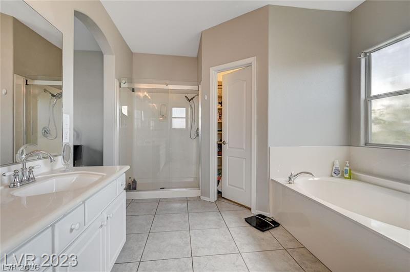 987 Cutter Street Henderson, NV 89011 - Photo 10 of 17 A pristine primary bathroom features a spacious shower, a deep soaking tub, and a vanity with ample storage.