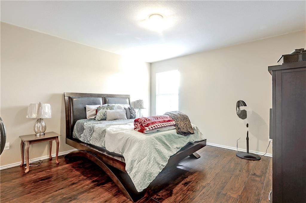 18316 Great Falls Drive Manor, TX 78653 - Photo 11 of 25 a bedroom with a bed and wooden floor