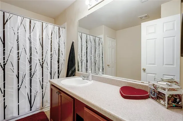 a bathroom with a sink a large mirror and a bathtub