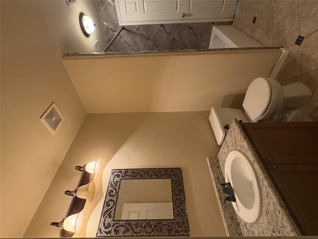 18316 Great Falls Drive Manor, TX 78653 - Photo 7 of 25 a bathroom with a toilet sink and mirror