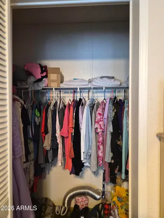a view of walk in closet with clothes