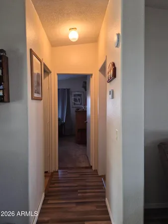 a view of a hallway with wooden floor and staircase