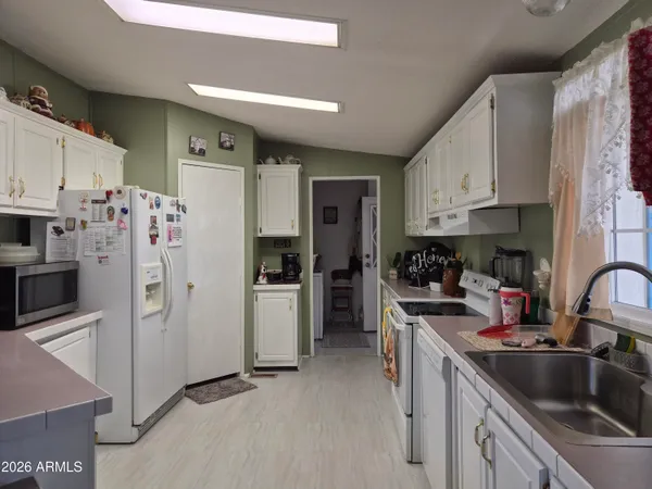 a kitchen with stainless steel appliances a refrigerator sink and cabinets