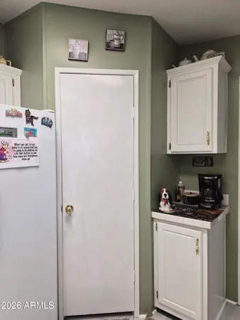 a kitchen with white cabinets and sink
