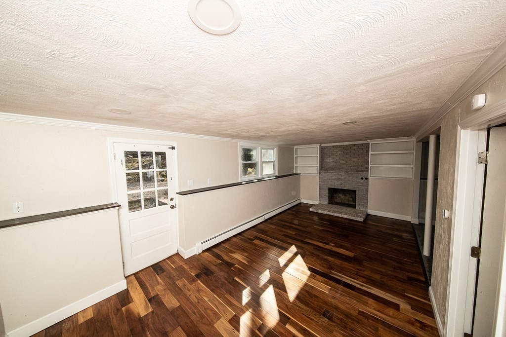 149 Salem Road Billerica, MA 01821 - Photo 16 of 21 a view of an empty room with wooden floor fireplace and a window