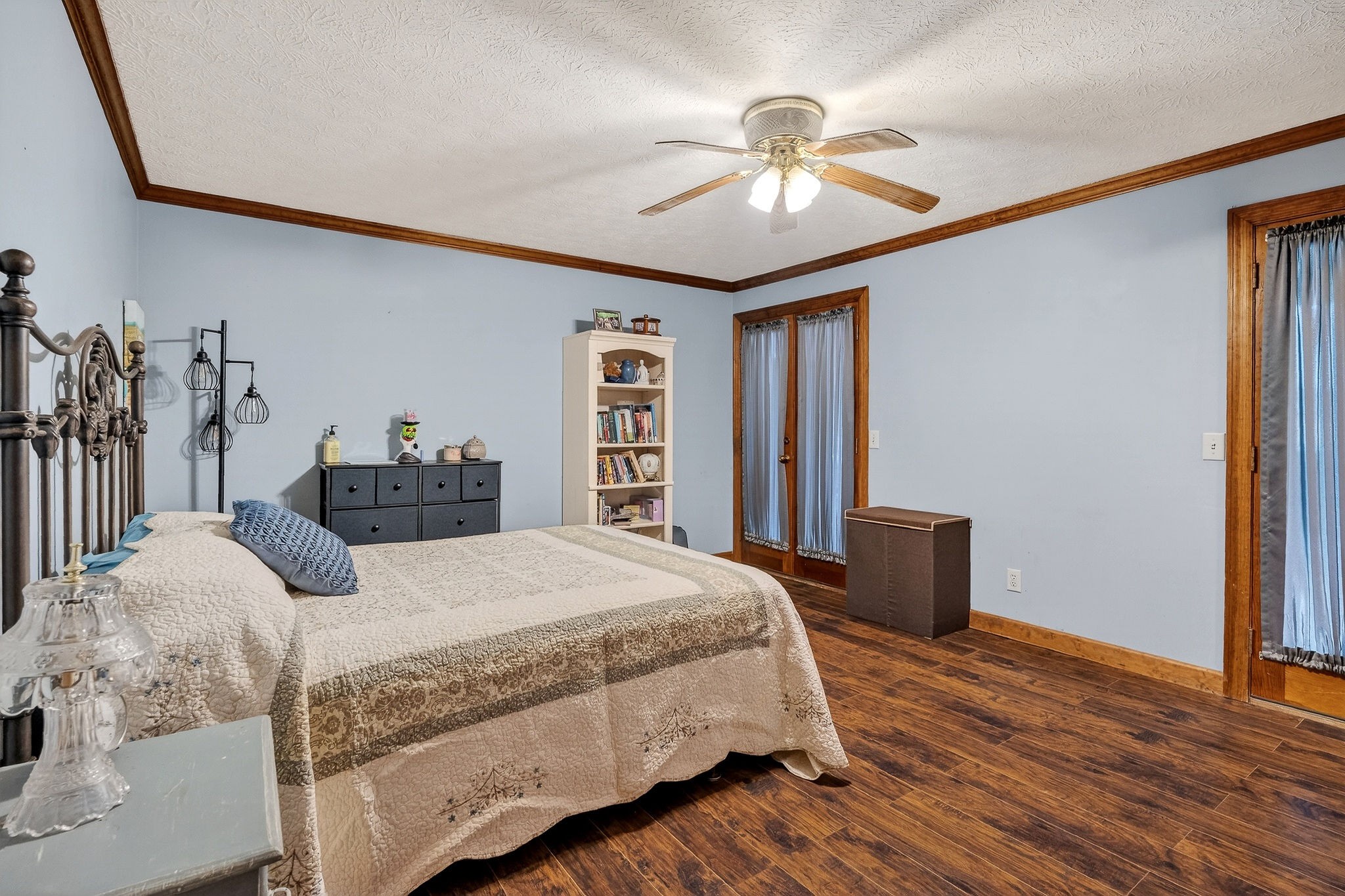 9334 Short Mountain Road Smithville, TN 37166 - Photo 17 of 51 a bedroom with a large bed and a chandelier