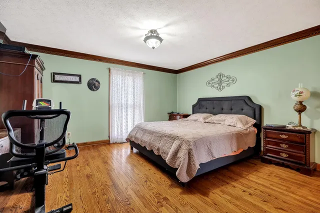 a bedroom with bed and wooden floor