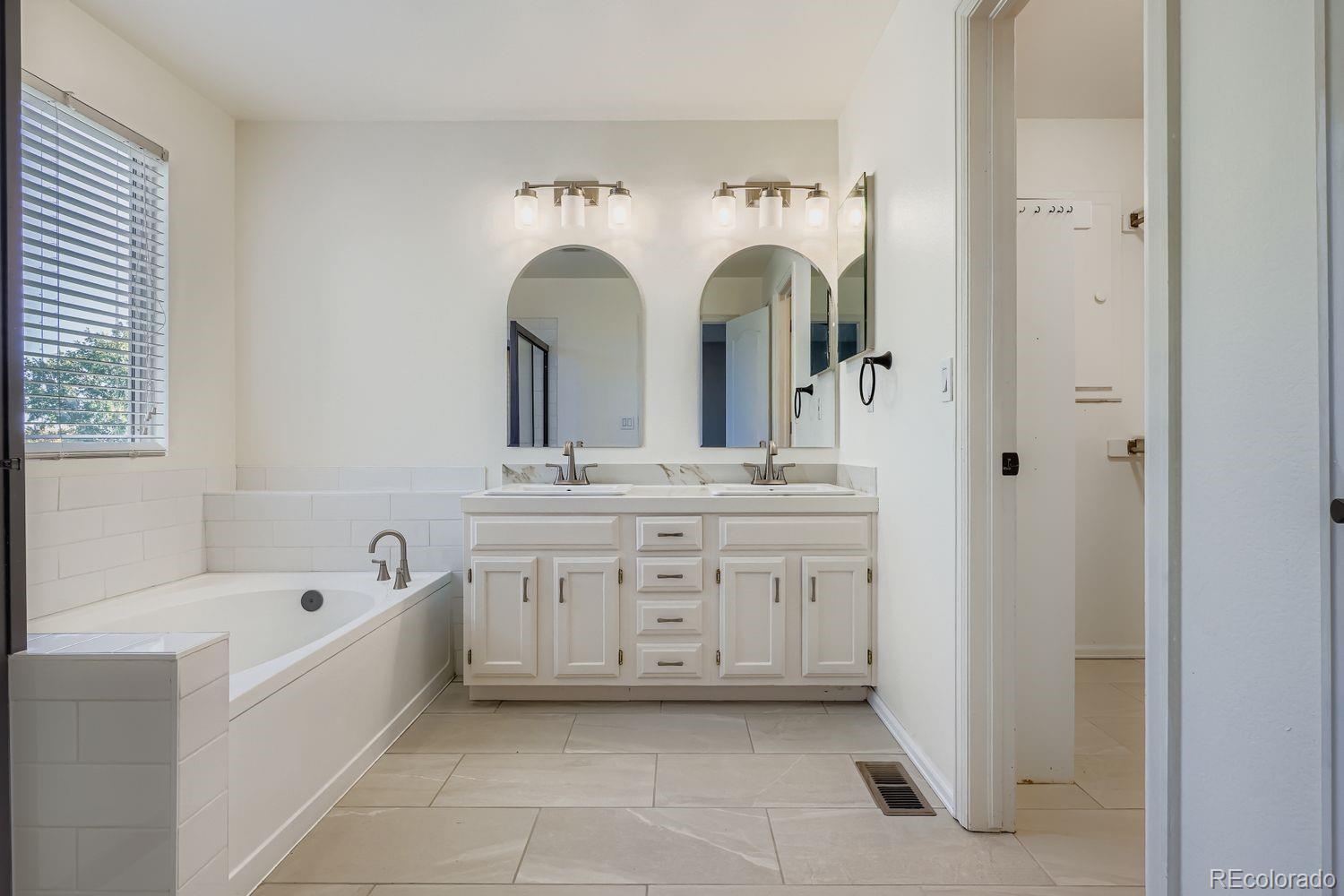 19827 East Prentice Avenue Centennial, CO 80015 - Photo 19 of 31 a spacious en suite bathroom with a granite countertop sink and a bathtub