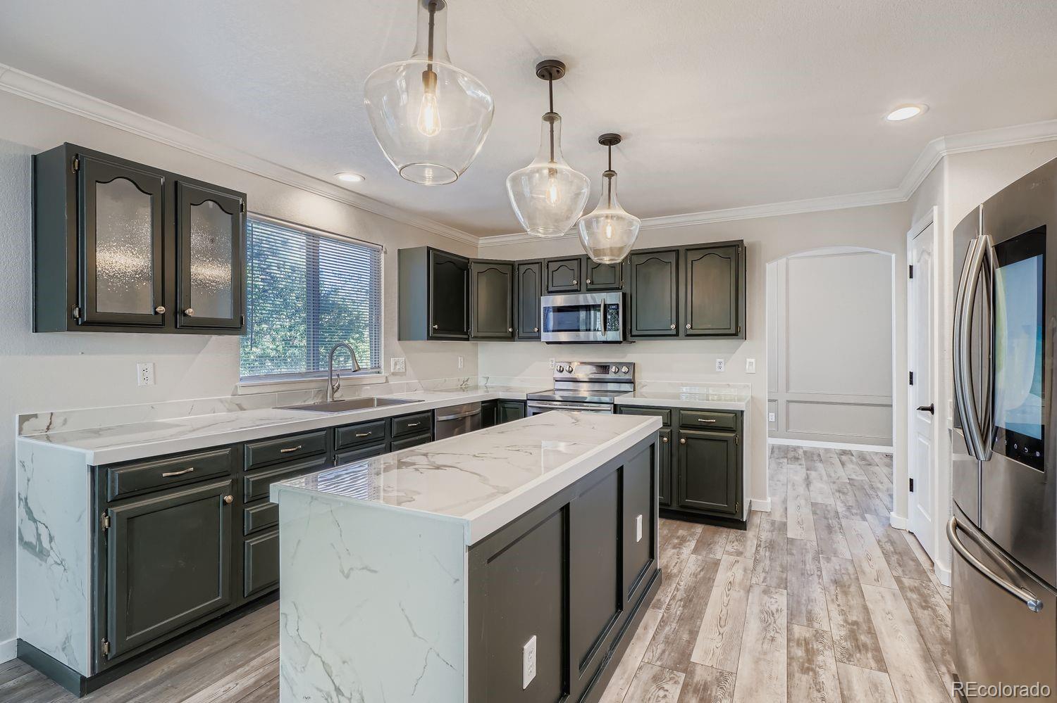 19827 East Prentice Avenue Centennial, CO 80015 - Photo 9 of 31 a kitchen with a sink stainless steel appliances a counter space and cabinets