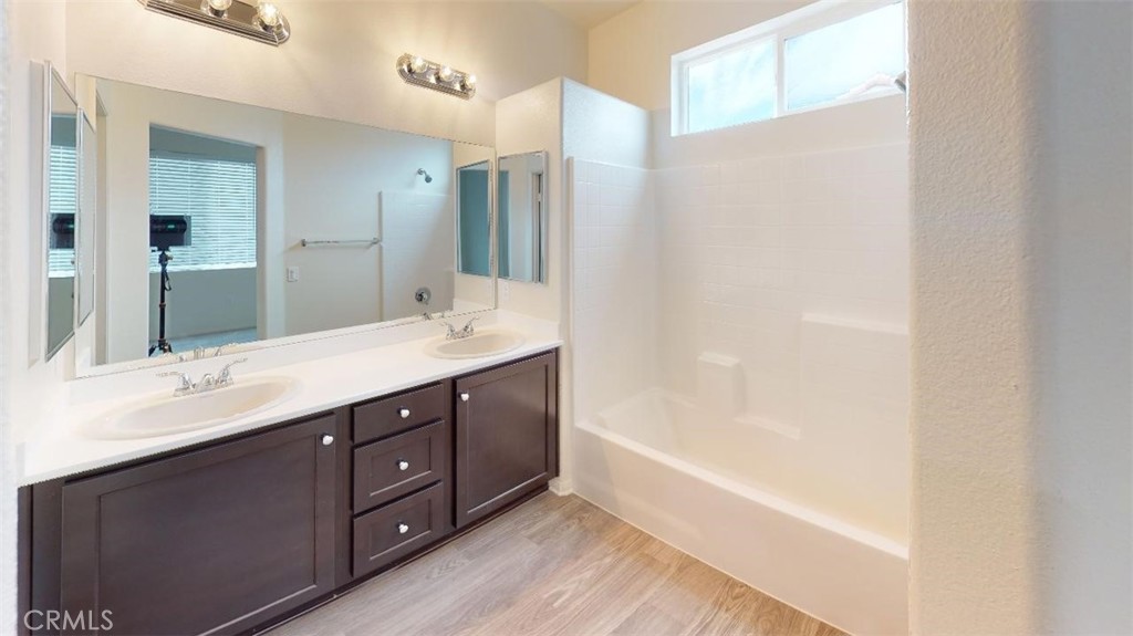 a bathroom with a tub sink and mirror