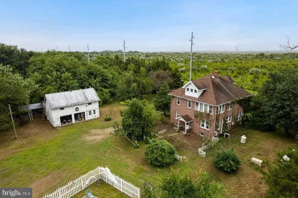 a view of a house with a big yard and potted plants