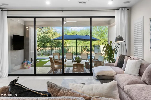 a living room with furniture and a floor to ceiling window