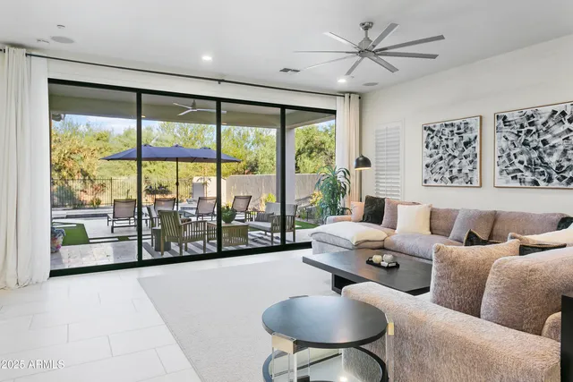 a living room with furniture and a large window with garden view