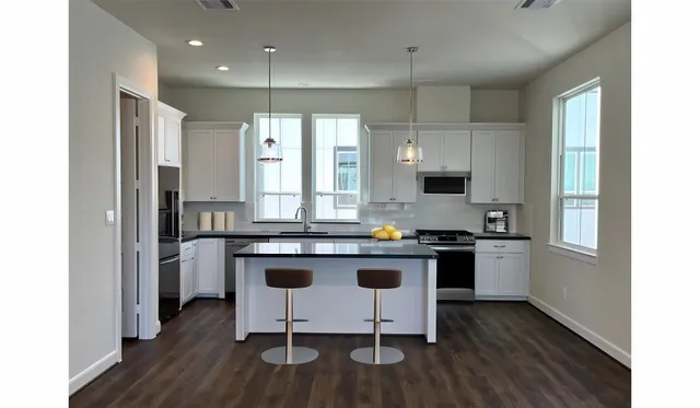 a kitchen with a sink cabinets and wooden floor
