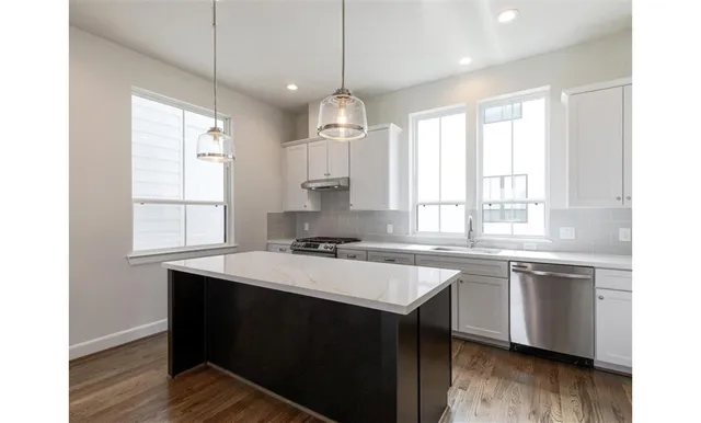 a kitchen with a sink stove and wooden floor