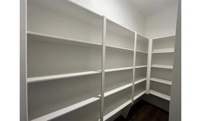 a view of walk in closet with empty racks