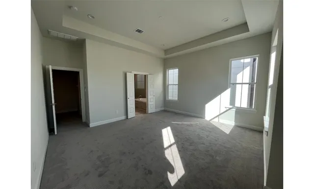 a view of a hallway with bathroom and a window