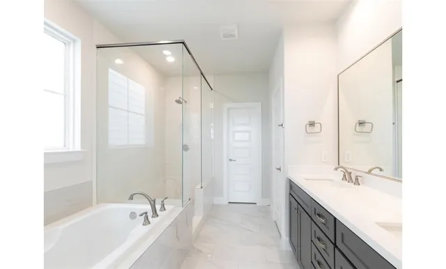 a bathroom with a tub sink and mirror