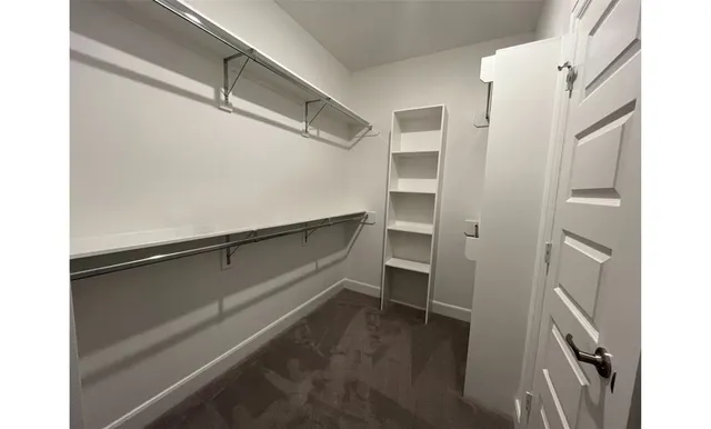 a view of walk in closet with empty racks