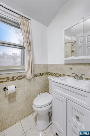 a bathroom with a granite countertop toilet a sink and a mirror