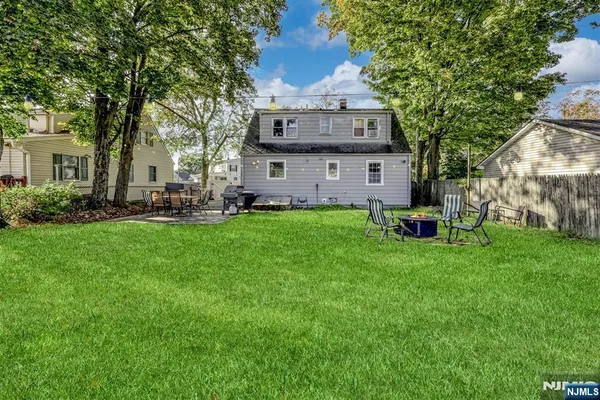 a view of a house with a big yard potted plants and large tree
