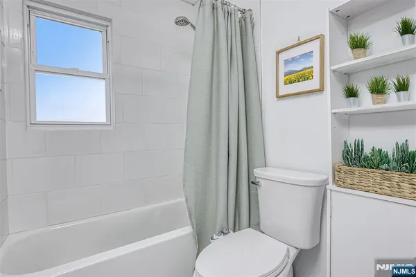 a white toilet sitting next to a bath tub