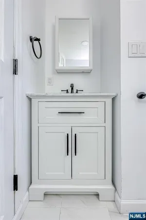 a bathroom with white cabinets and a sink