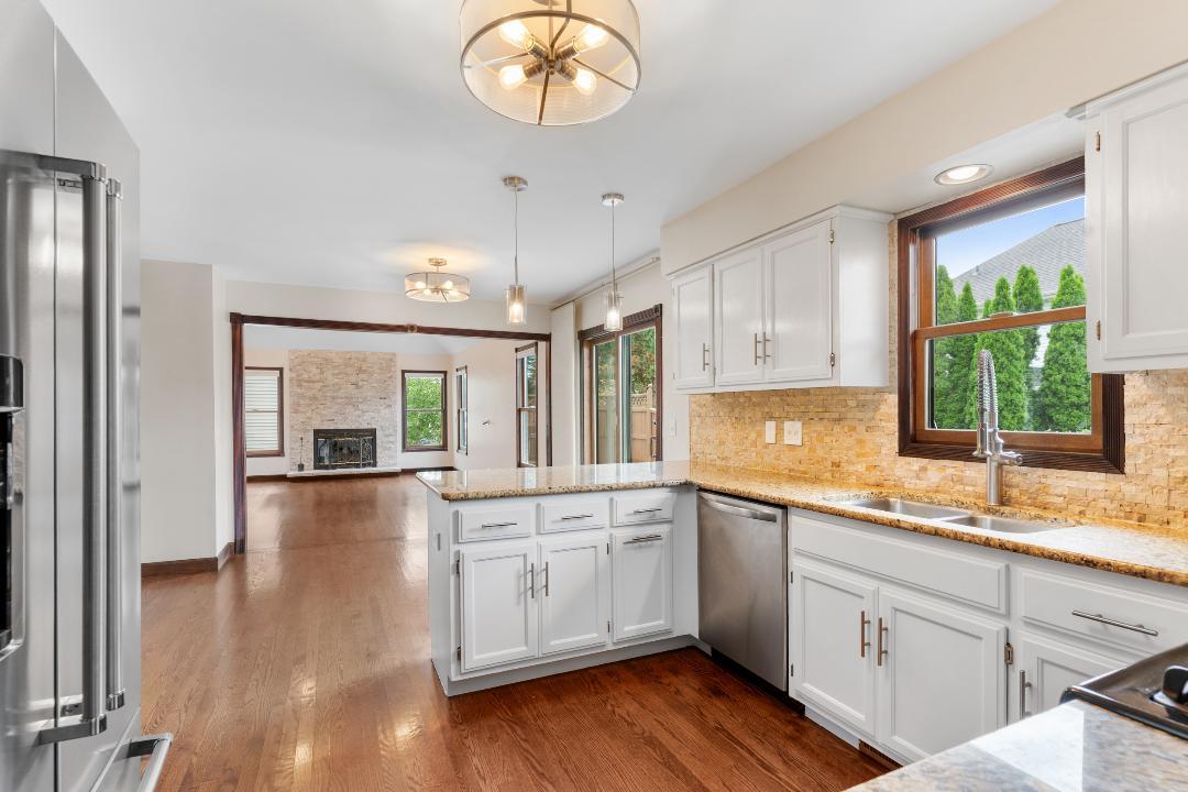 1715 Chestnut Hill Road Plainfield, IL 60586 - Photo 7 of 16 a kitchen with a sink dishwasher a stove and white cabinets with wooden floor
