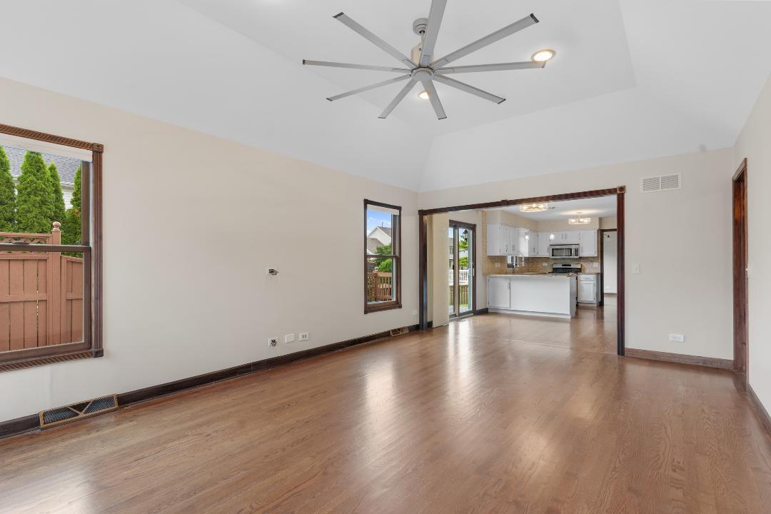 1715 Chestnut Hill Road Plainfield, IL 60586 - Photo 9 of 16 an empty room with wooden floor and a ceiling fan