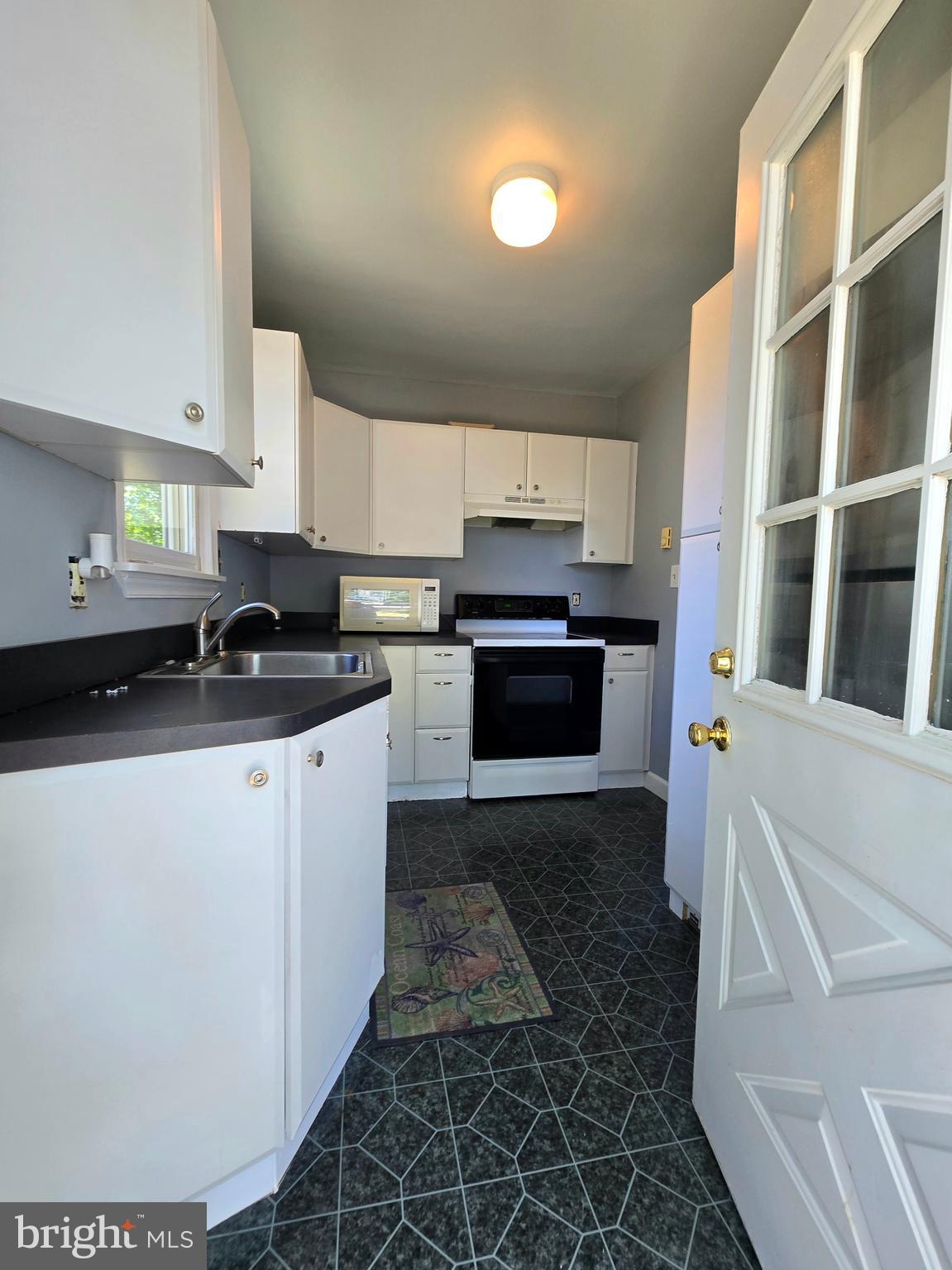 151 Riviera Drive Pasadena, MD 21122 - Photo 38 of 72 a kitchen with granite countertop a stove a sink and a microwave