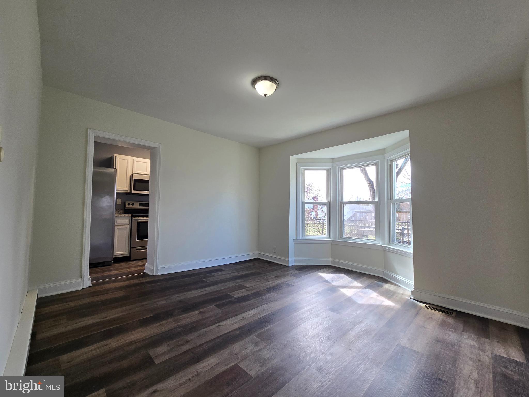 151 Riviera Drive Pasadena, MD 21122 - Photo 4 of 66 a view of an empty room with wooden floor and a window
