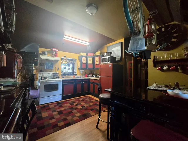 a view of a park with large trees and a barn in it